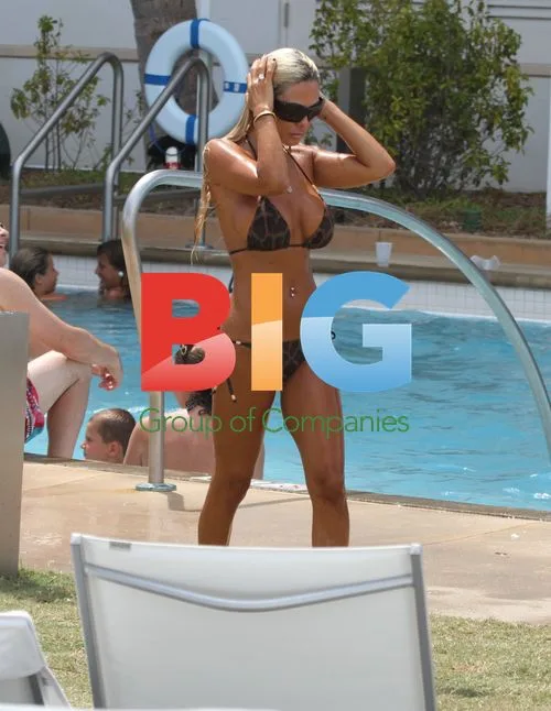 Shauna Sand relaxes poolside with daughters