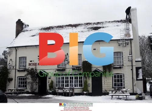 Man works on snowy rooftop in Thorpe, UK