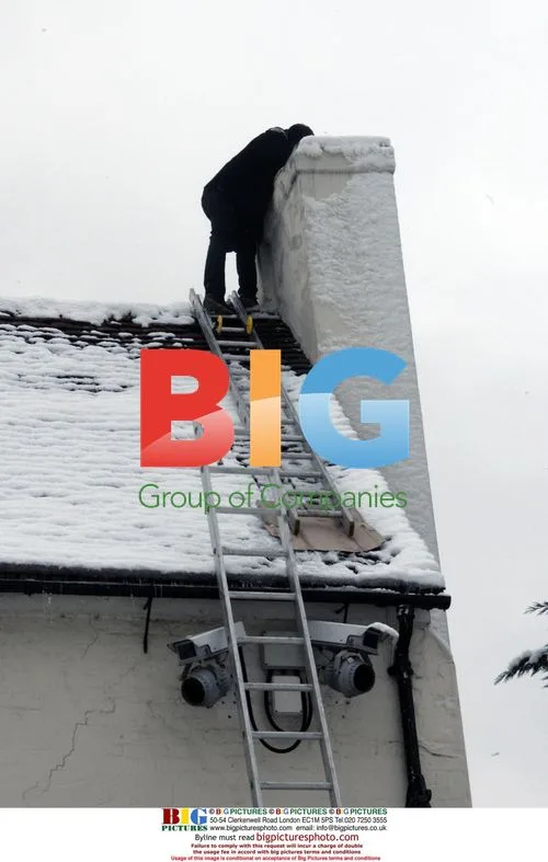 Man works on snowy rooftop