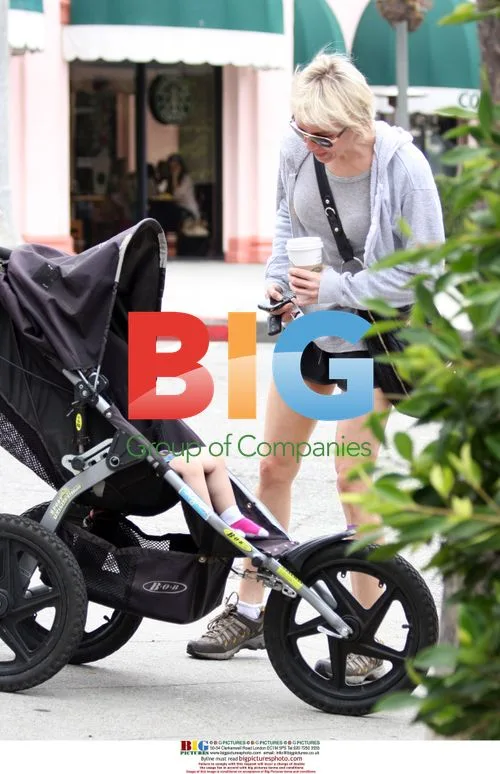 Renee Zellweger talks to fans and holds baby