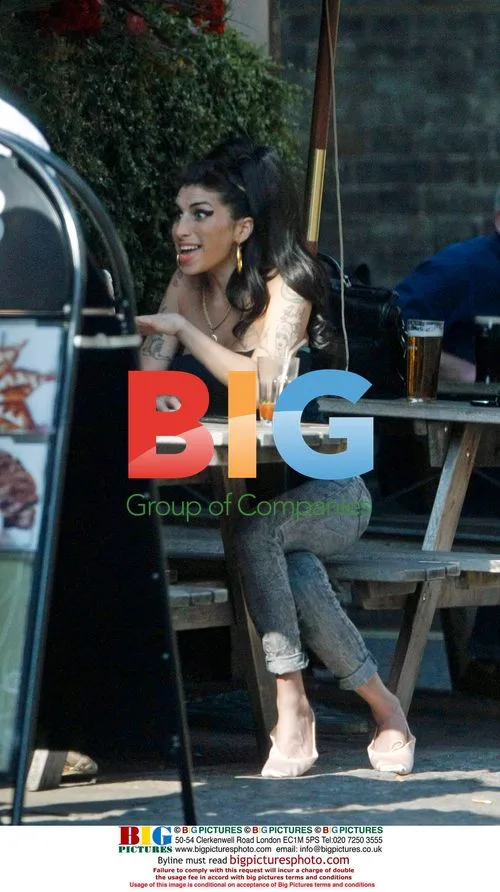 Amy Winehouse Interacts with Child at Pub