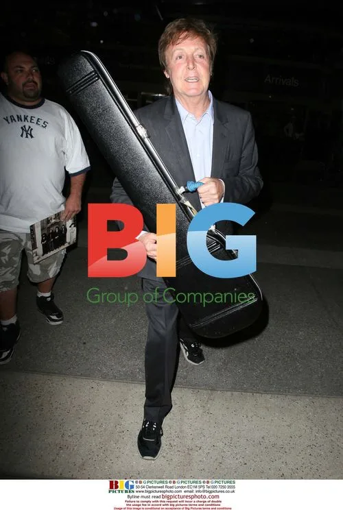 Sir Paul McCartney Arrives at LAX with Guitar