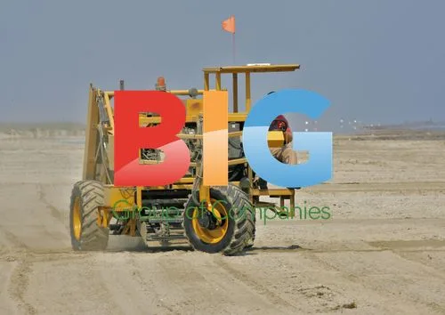 Worker drives sand skimmer on beach in Grand Isle, Louisiana