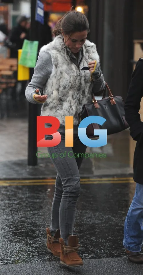 Pippa Middleton shelters from rain in London