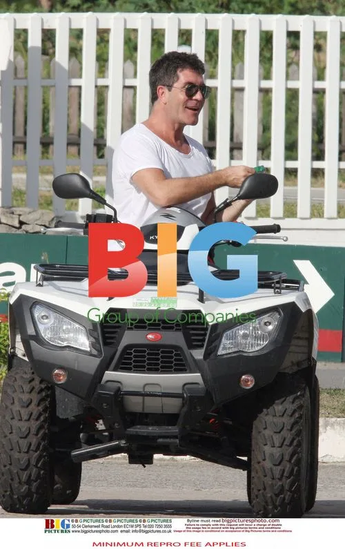 Simon Cowell rides quad bike with partner