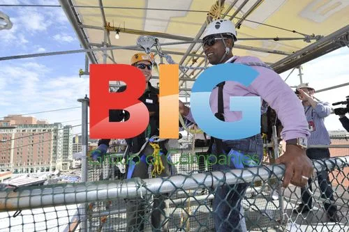 Cory Murphy helps Cris Carter zip line at Super Bowl
