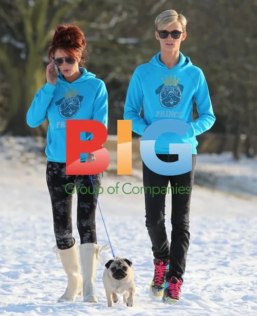 Amy Childs and Harry Derbidge play in snow with pug