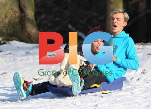 Amy Childs and Harry Derbidge play in snow with pet pug