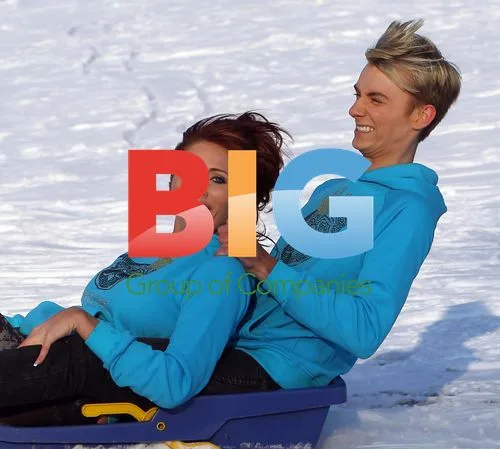 Amy Childs and cousin Harry playing in snow with pug