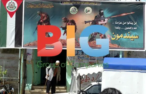 Palestinian man walks by resistance poster in Gaza