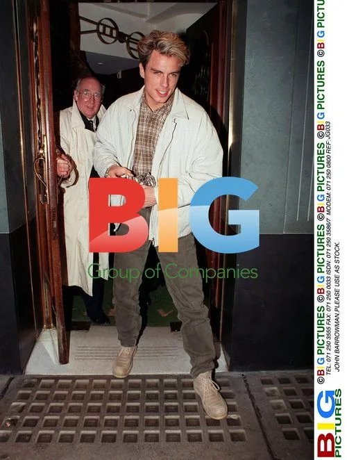 John Barrowman in white jacket and brown trousers