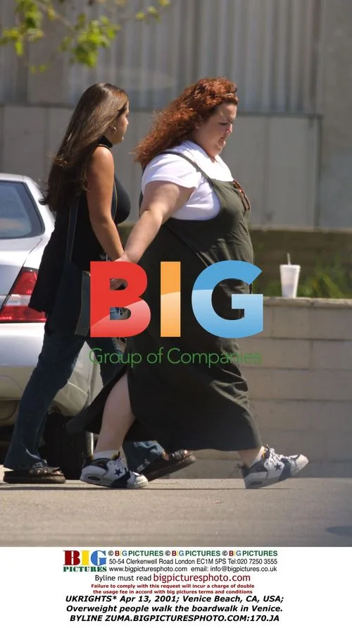 Overweight people walk Venice Beach boardwalk