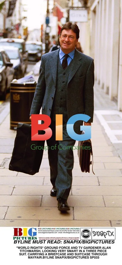Alan Titchmarsh in Suit Carrying Luggage