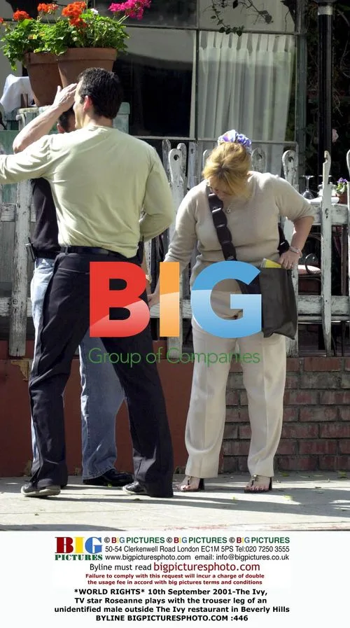 Roseanne plays with man's trouser leg at The Ivy