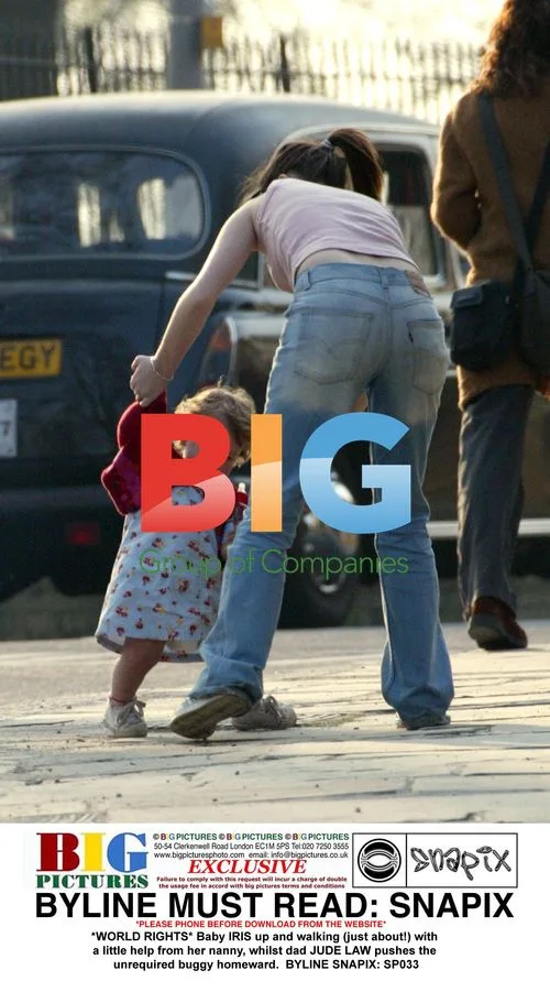Baby IRIS walks with nanny as Jude Law pushes empty buggy