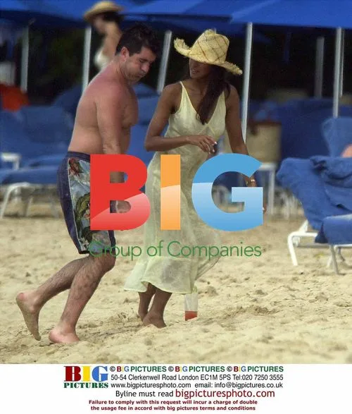 Simon Cowell on Beach with Young Woman