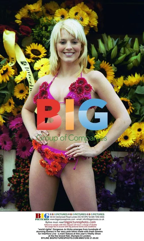 Jo Hicks emerges from flowers in pink floral bikini