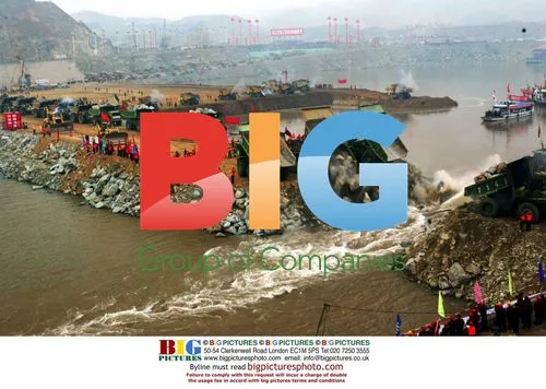 Trucks dump rocks to dam diversion canal of Three Gorges project
