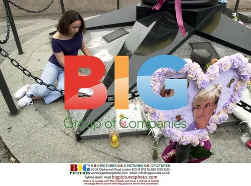 Girl places flower at Diana shrine in Paris