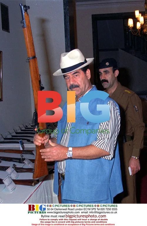 Saddam Hussein Holds Rifle