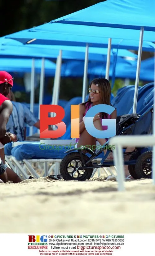 Model Jordan and Dwight Yorke with baby on beach