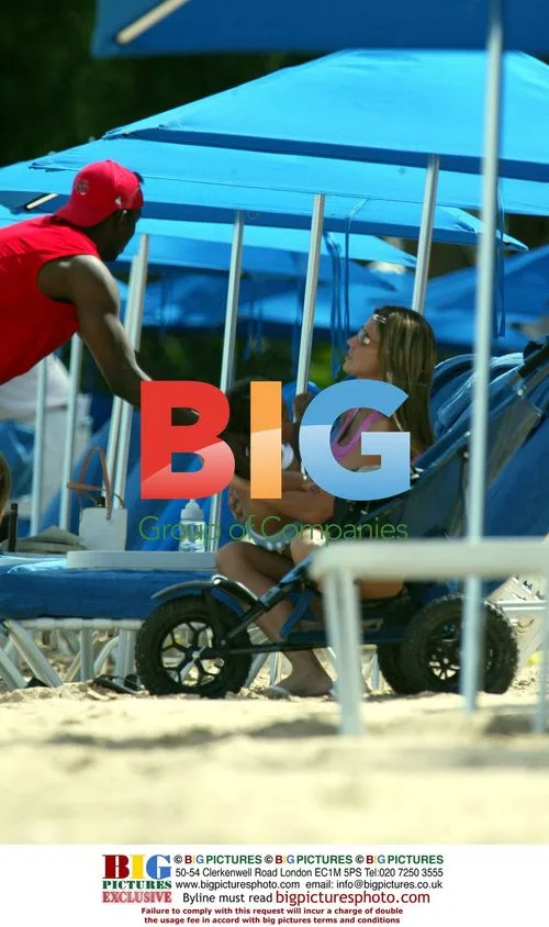 Jordan and Dwight Yorke with baby on Caribbean beach