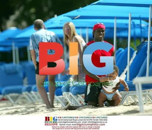 Model Jordan and Dwight Yorke with baby on Caribbean beach