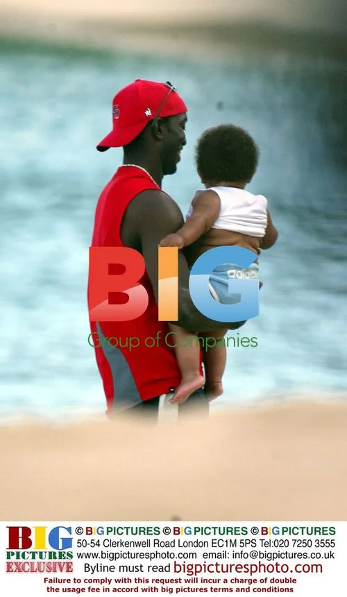 Jordan, Dwight Yorke, and baby Harvey on beach