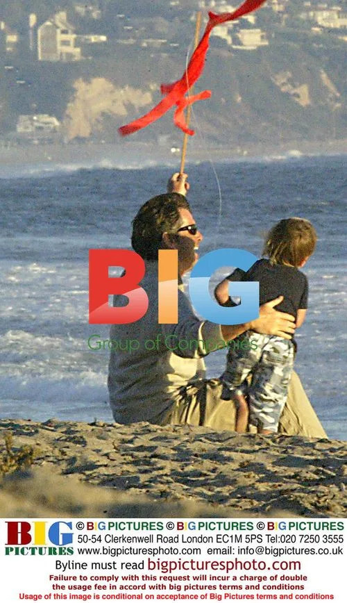 Pierce Brosman plays with kids on beach