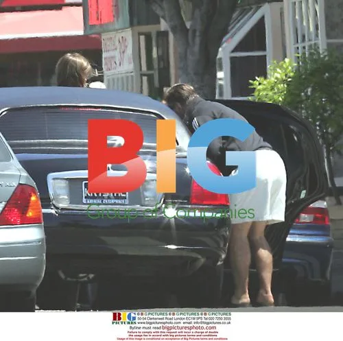 Alec Baldwin with coffee and papers in limo