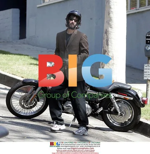 Keanu Reeves gestures to paparazzi