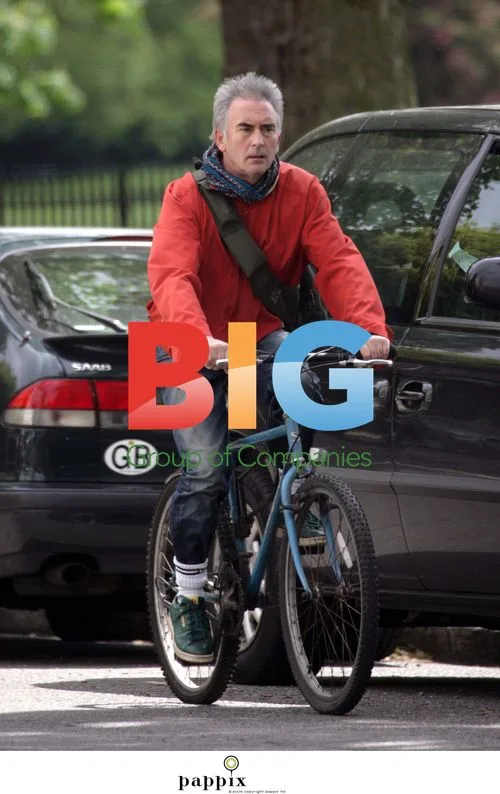 Dennis Lawson rides bike in London