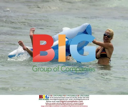 Models Lucy and Malene playing in surf with inflatable