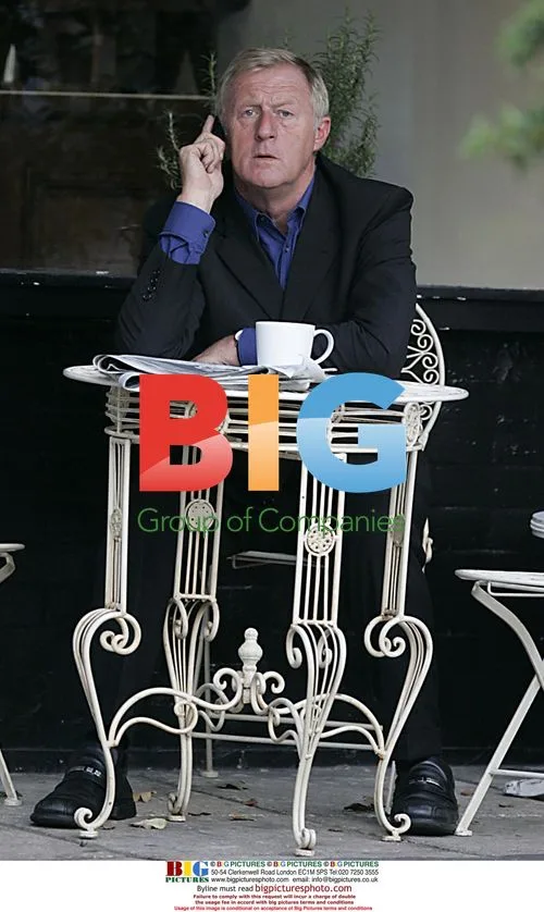 Chris Tarrant chats on phone outside London cafe