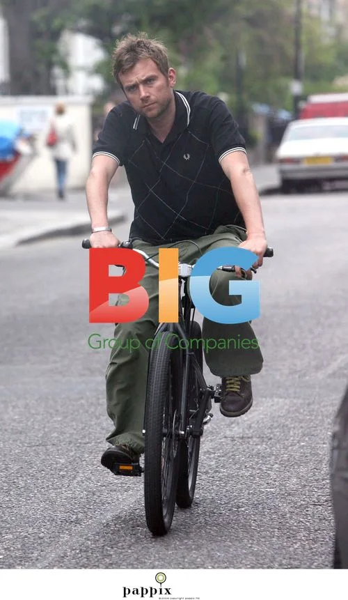 Damon Albarn cycling in bright pink pants