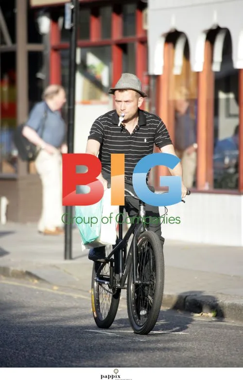 Damon Albarn rides bike with keys in mouth