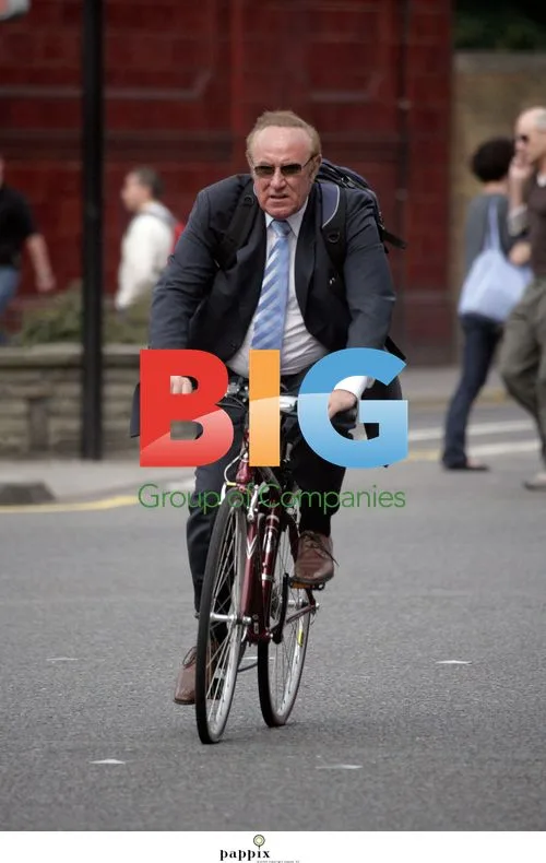 Andrew Neill riding bike without helmet in London