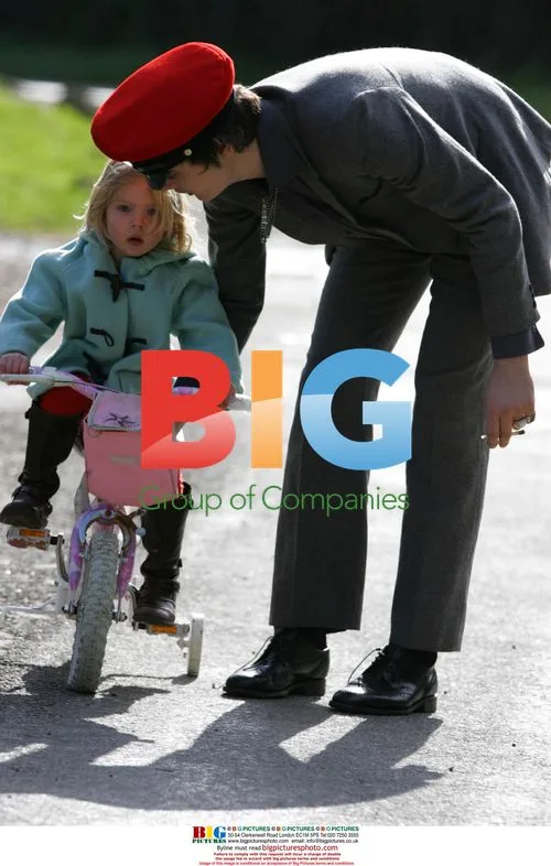 Man in grey suit on bike holding hands with woman