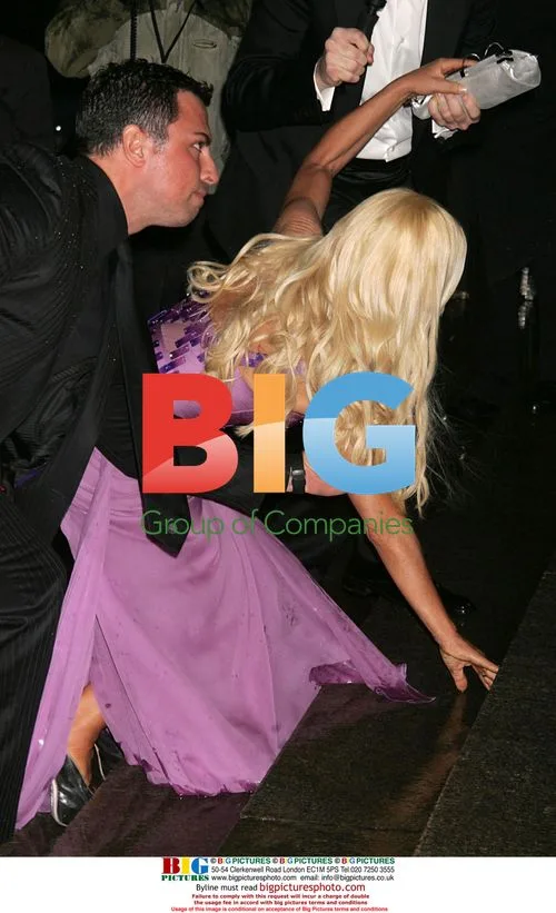 Donatella Versace slips on wet steps