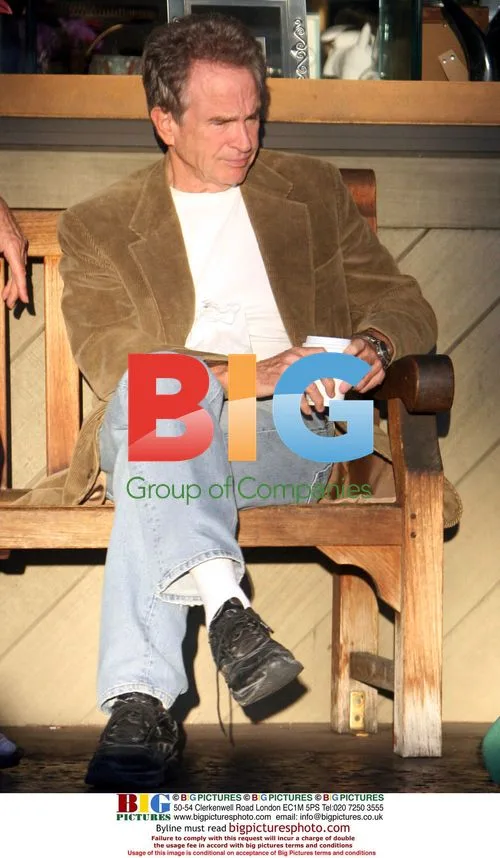 Warren Beatty Enjoying Cup of Coffee on Park Bench