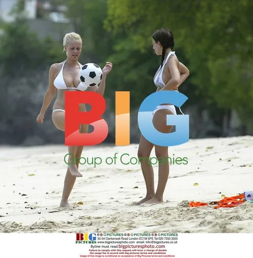 Sexy models play football on beach