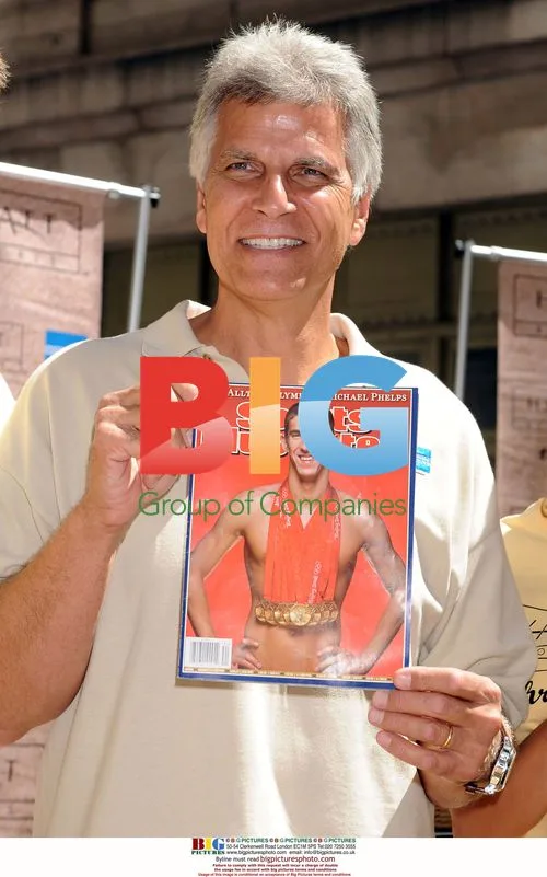 Mark Spitz holding Michael Phelps magazine