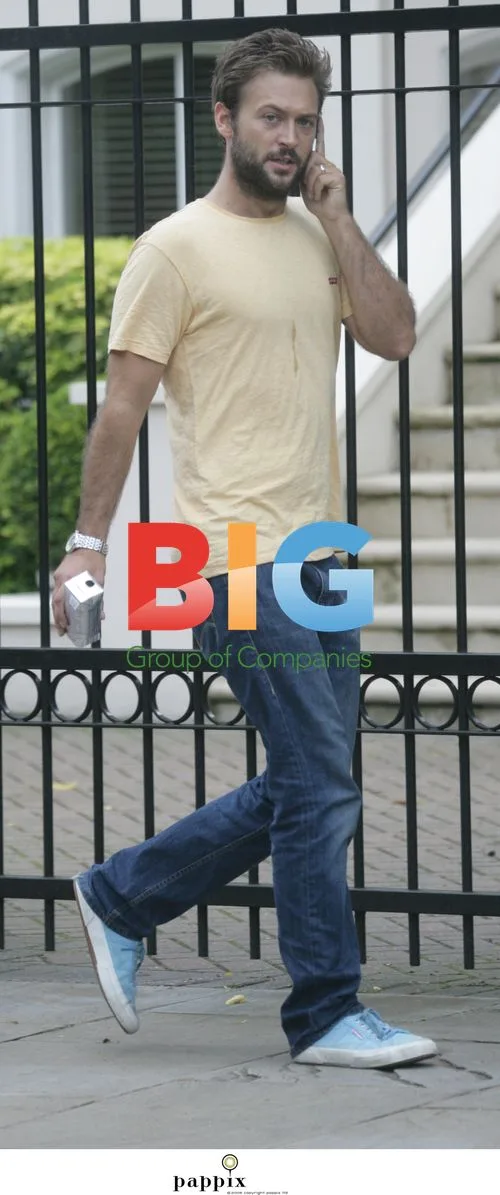 Actor Paul Nicholls chats on mobile in London