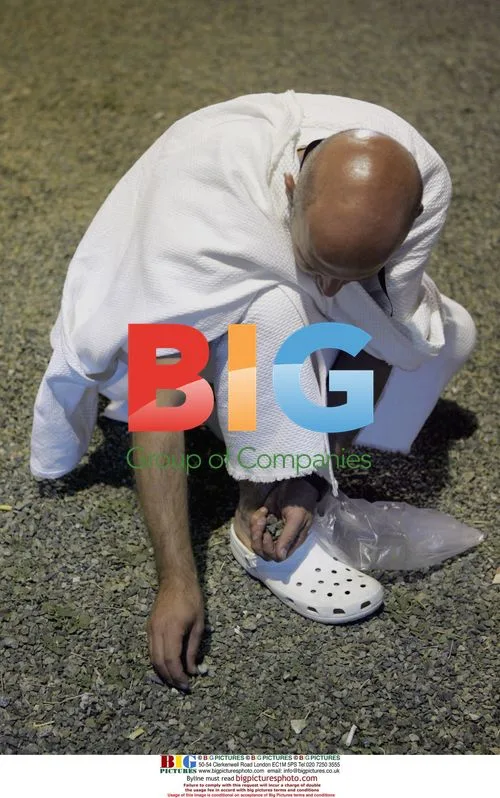 Muslim pilgrim collects stones in Mecca