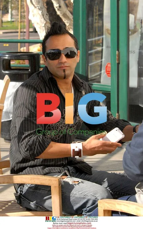 Adnan Ghalib in Malibu using two cell phones