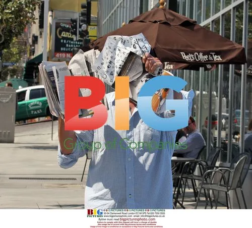 Chris Noth reads newspaper at cafe