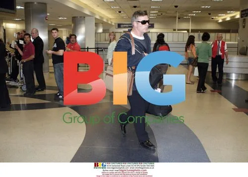 Alec Baldwin carrying own luggage at LAX