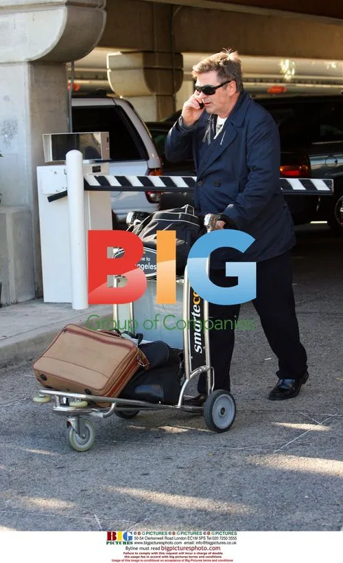 Alec Baldwin Carries Own Luggage at LAX