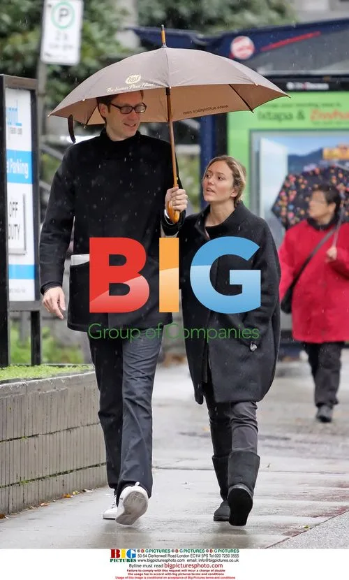 Stephen Merchant and girlfriend walk in the rain