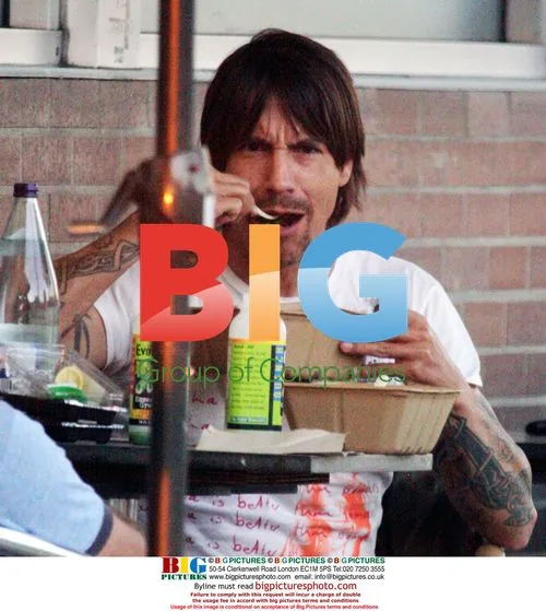 Anthony Kiedis makes funny faces while eating outside